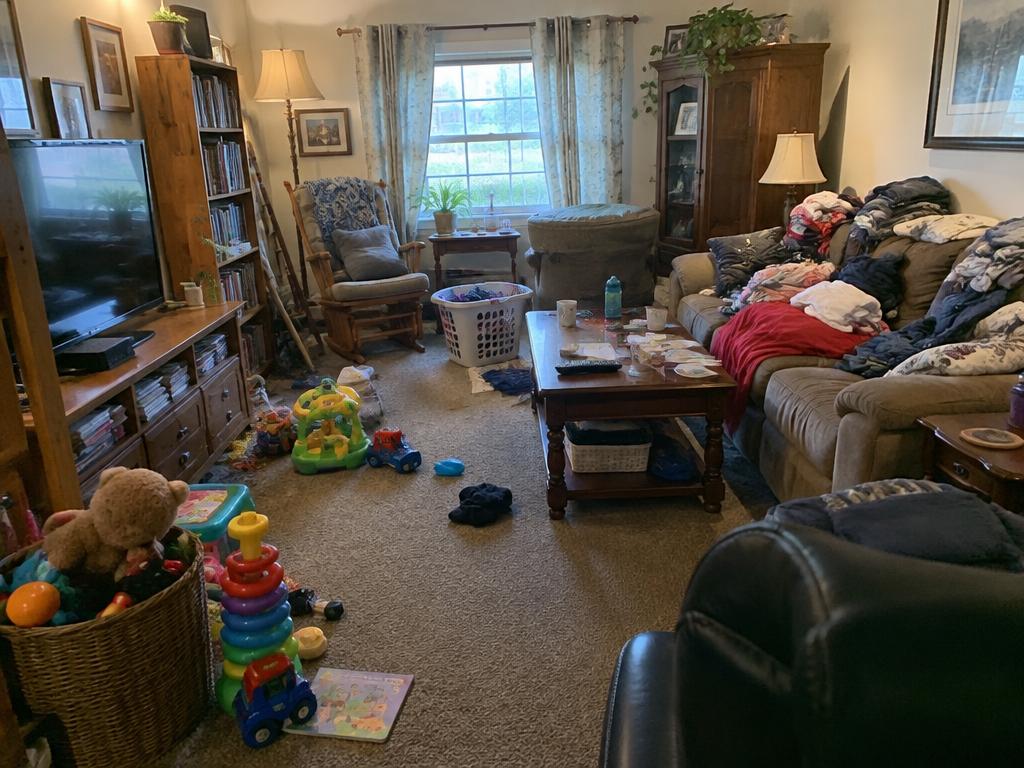 A busy family living room with toys and laundry