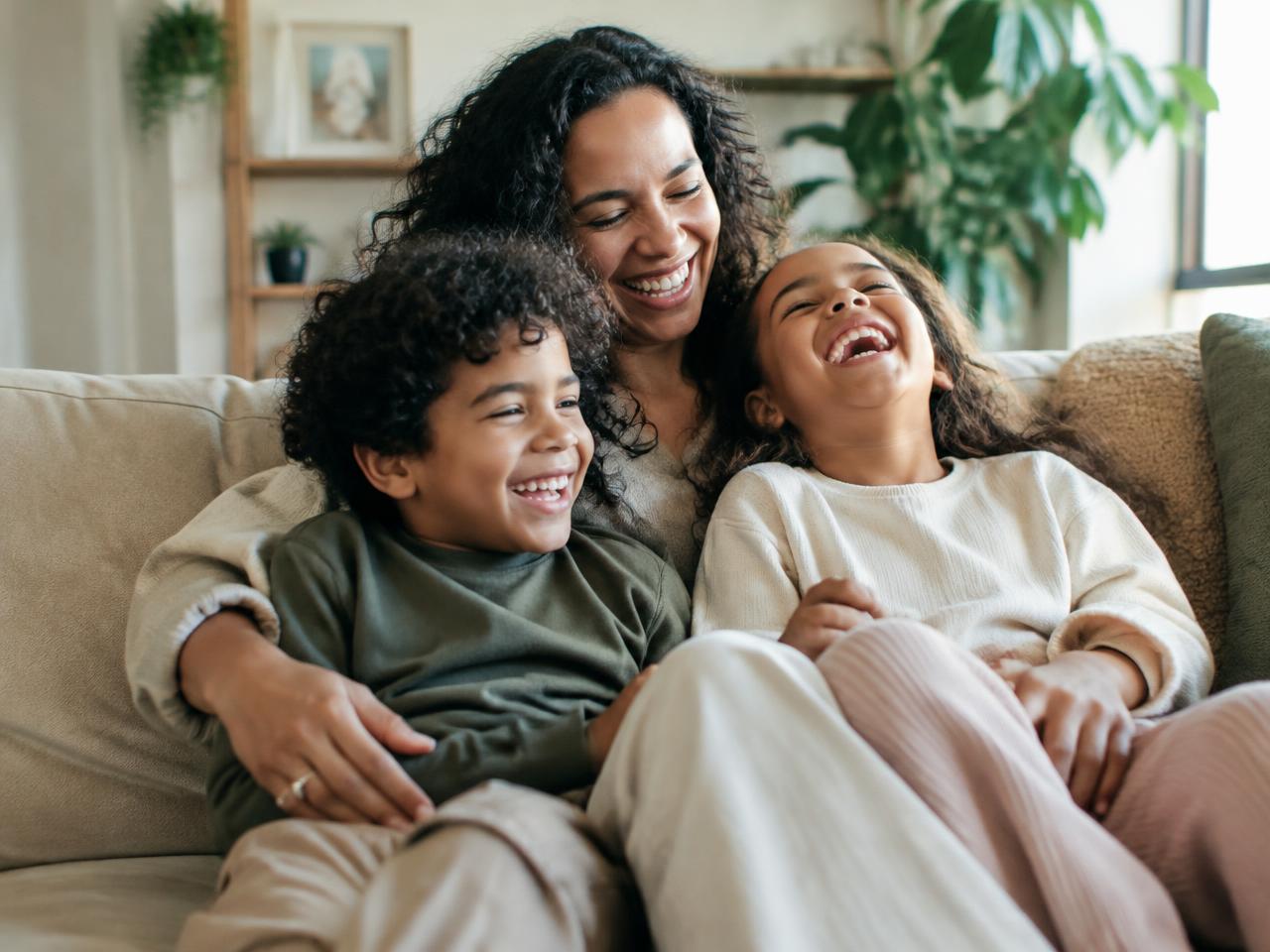 Family laughing together on the sofa
